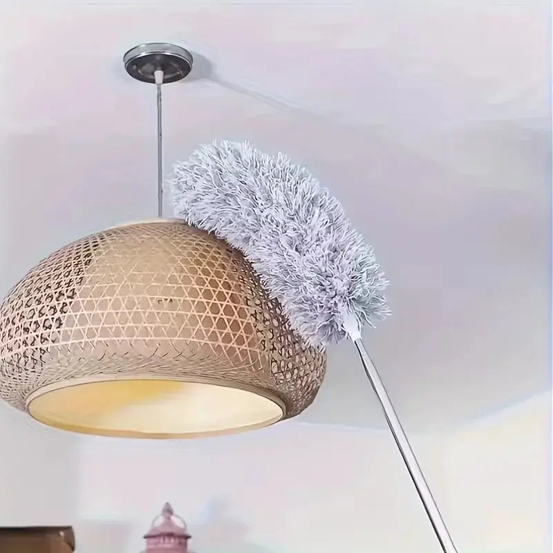 Duster with extension rod and fluffy gray microfiber head beside a pendant ceiling light