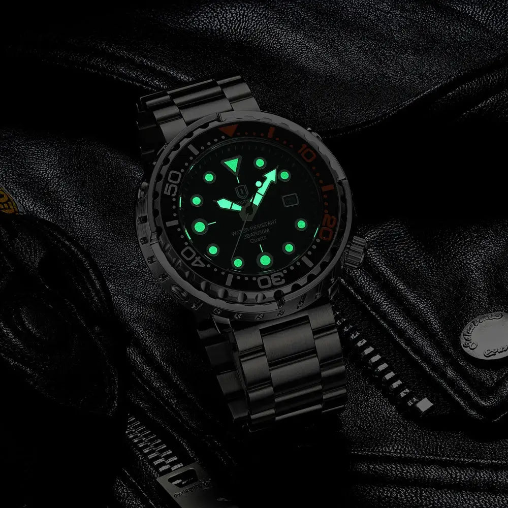 Men's diver-style wristwatch with black dial, green luminous markers, orange-accent bezel, and stainless steel bracelet.