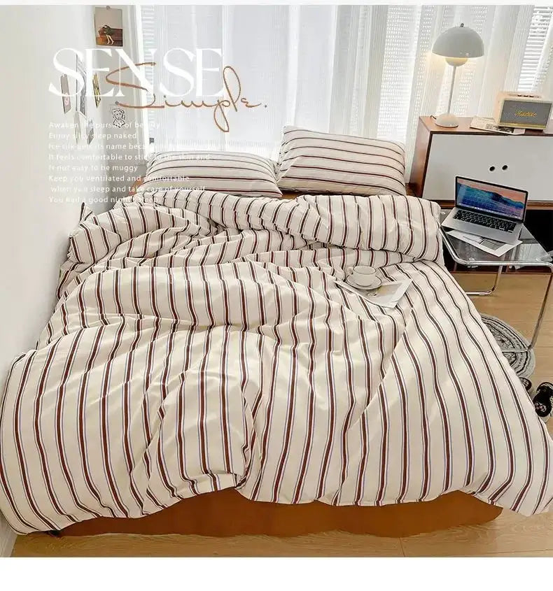 Striped duvet cover and four-piece washed cotton bed sheet set in red and blue, on bed.