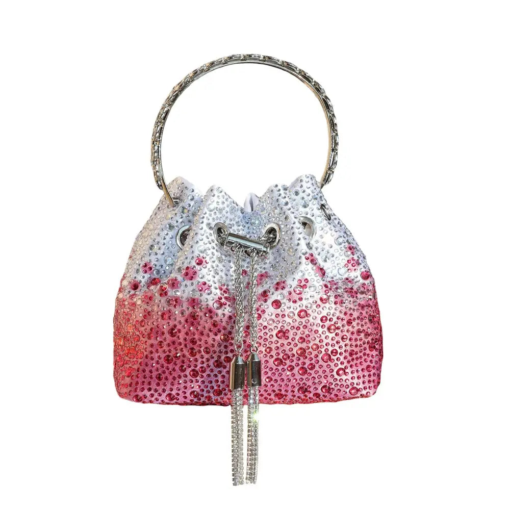 Simples Market rhinestone evening bucket clutch bag with gradient white-to-pink crystals and a circular jeweled handle.