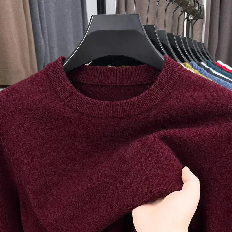 Men's burgundy round-neck knitted sweater with long sleeves on a hanger.