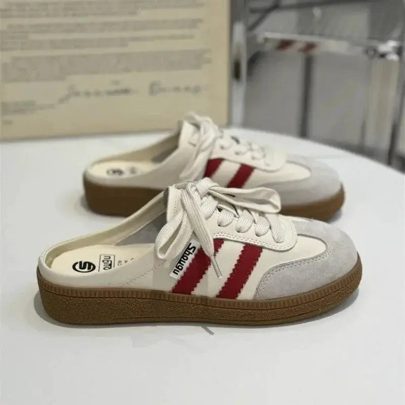 Women’s mule sneakers by Simples Market with white upper, red stripes, round toe, brown sole.