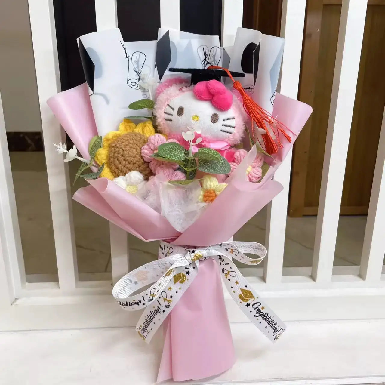 Stuffed Hello Kitty bouquet with pink wrapping, plush kitty, yellow and pink crochet flowers, and green leaves