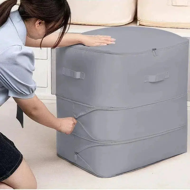 Heavy-duty self-compressing storage bag in gray for clothes and blankets; portable closet organizer.
