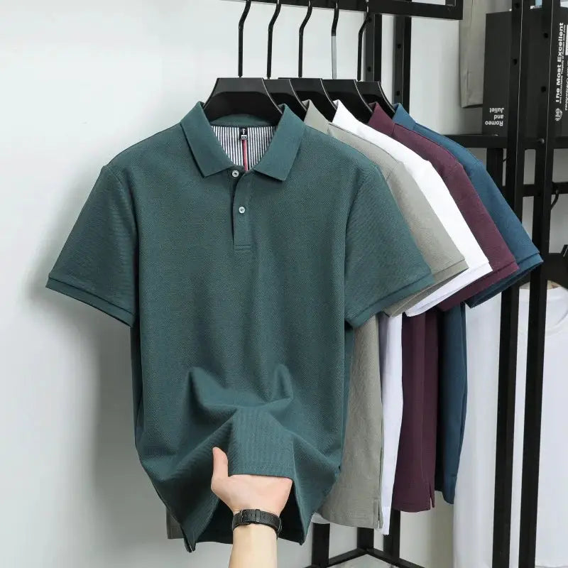 Polo shirts on hangers; teal 100% cotton polo in front, Simples Market, with assorted colors behind