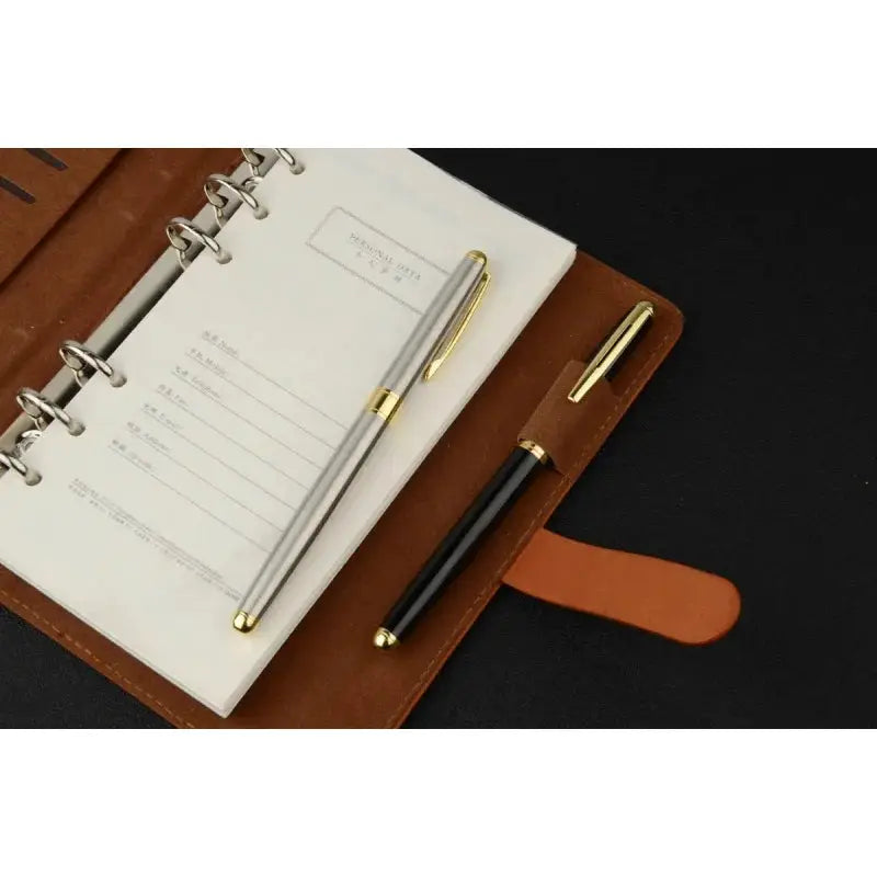 Ballpoint pen set by Simples Market; silver stainless steel pen with gold trim and black pen with gold accents, 2 pens