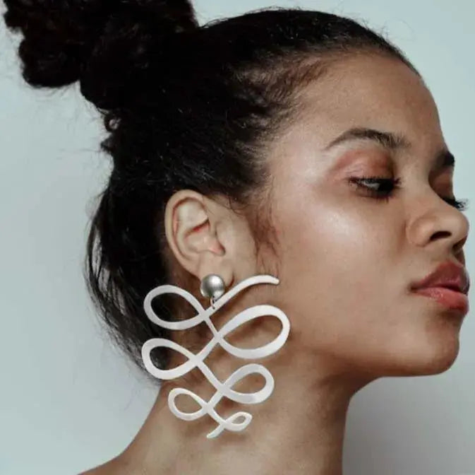 Large squiggle dangle earrings by Simples Market; white abstract loop design, one pair