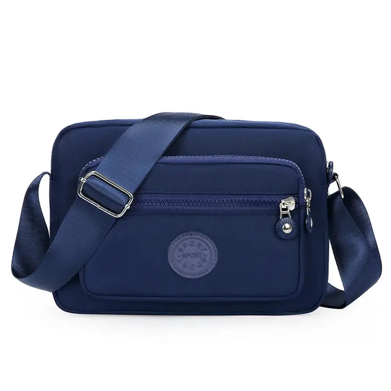 Simples Market navy crossbody bag with adjustable strap, logo patch, and front zipper pocket