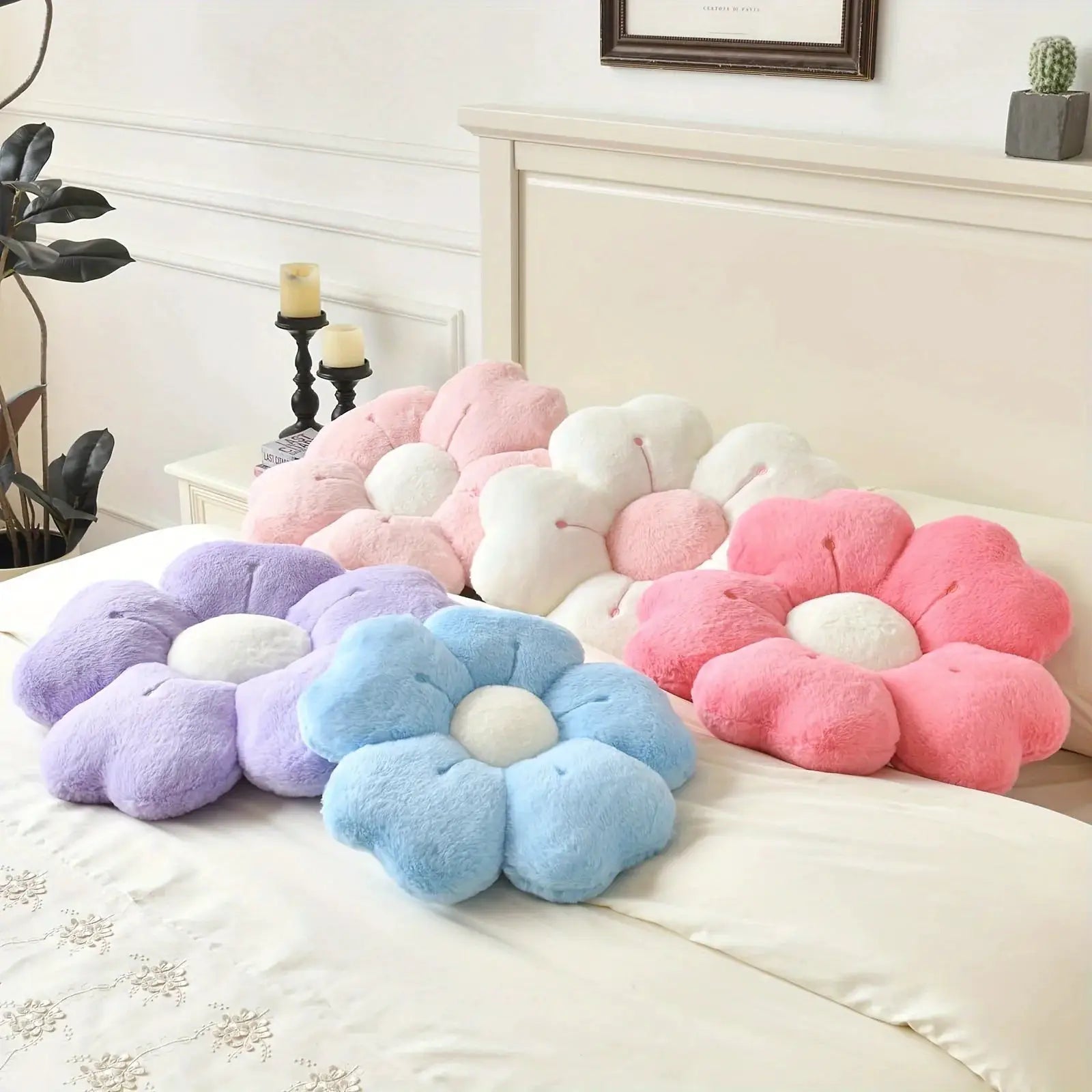 Simples Market flower-shaped plush throw pillows in pastel purple, blue, pink and white on a bed