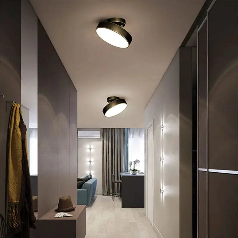 Modern round LED ceiling lights by Simples Market, black exterior with copper interior; two fixtures in hallway.