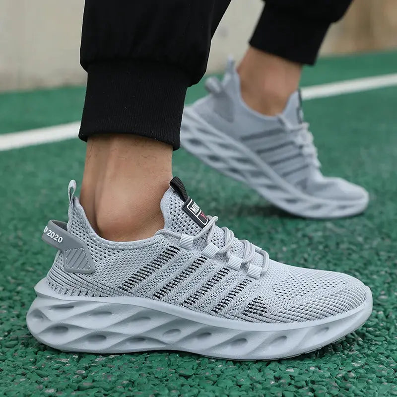Gray knit unisex sneakers with a wave-pattern sole, breathable running shoes