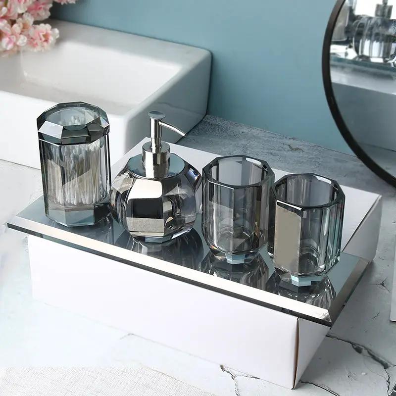 Crystal glass bathroom accessory set, 4 pieces, including pump bottle, jar with lid, and two cups.