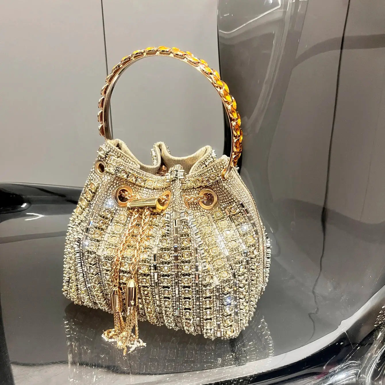 Crystal bucket bag with gold-tone handle and rhinestone embellishments