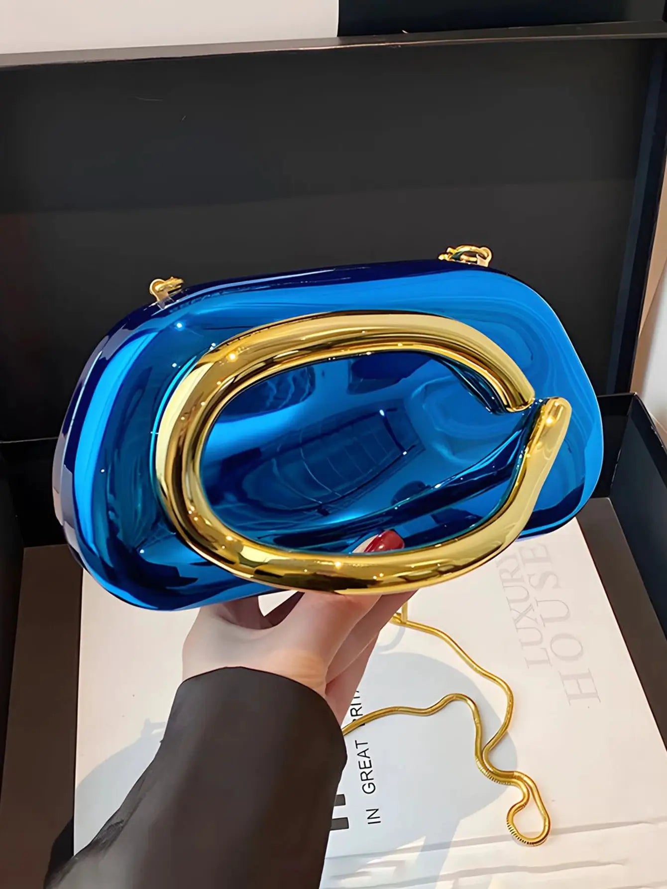 Blue acrylic box-shaped crossbody bag with gold-tone hardware and chain strap