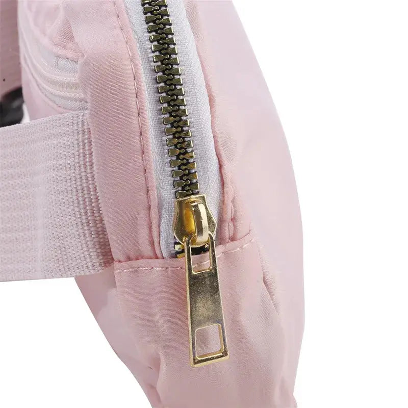 Waist bag in pink with gold zipper and adjustable strap for casual travel
