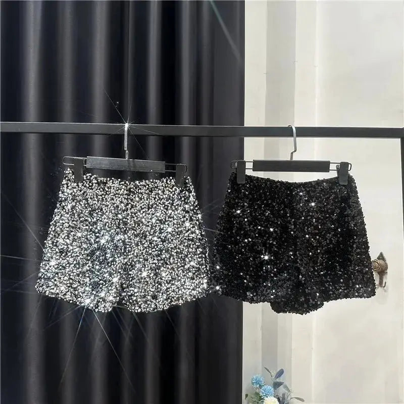 Two women's sequined shorts in silver and black by Simples Market; glittery clubwear bottoms
