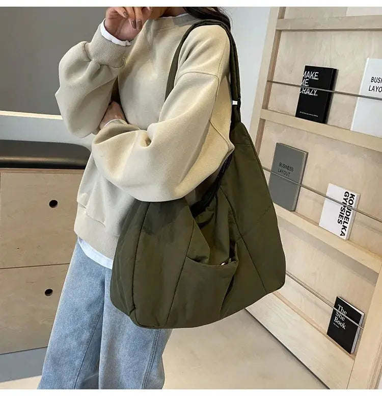 Olive green soft-cloth shoulder bag with a large slouchy shape and front pocket