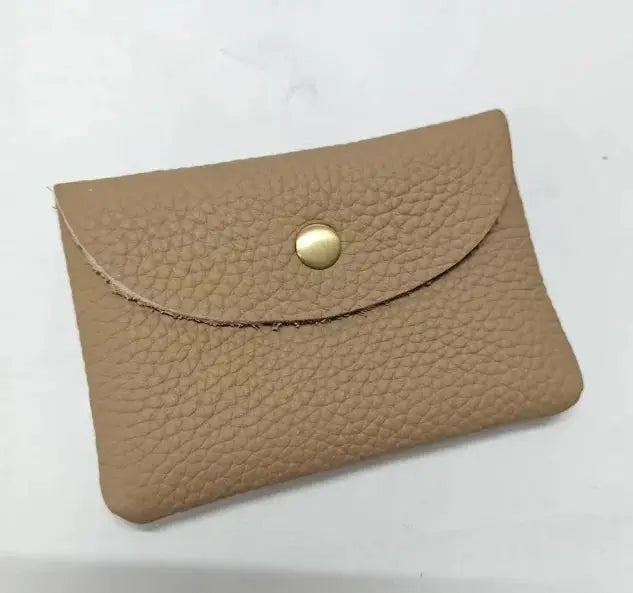 Simples Market tan pebble leather card holder with curved envelope-style flap.