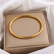Gold-tone stainless steel cuff bracelet for women, openable smooth bangle in a beige jewelry box