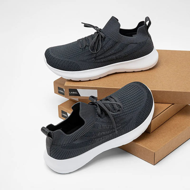 HOBIBEAR unisex running sneakers, black mesh knit with white sole, two sneakers on cardboard boxes.