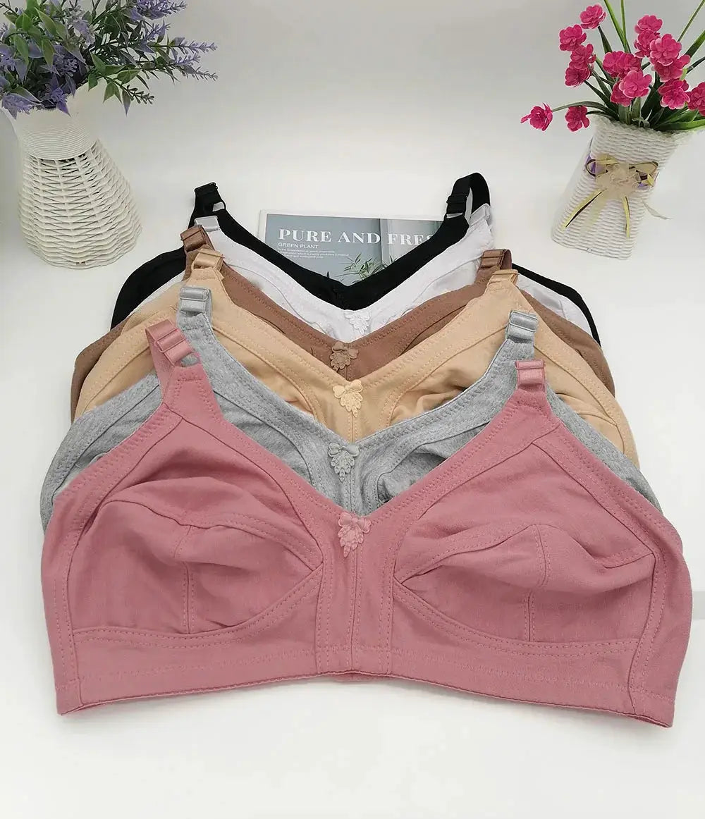 Six plus-size bras stacked in pink, gray, beige, taupe, brown and black; seamless non-padded push-up full-cup set