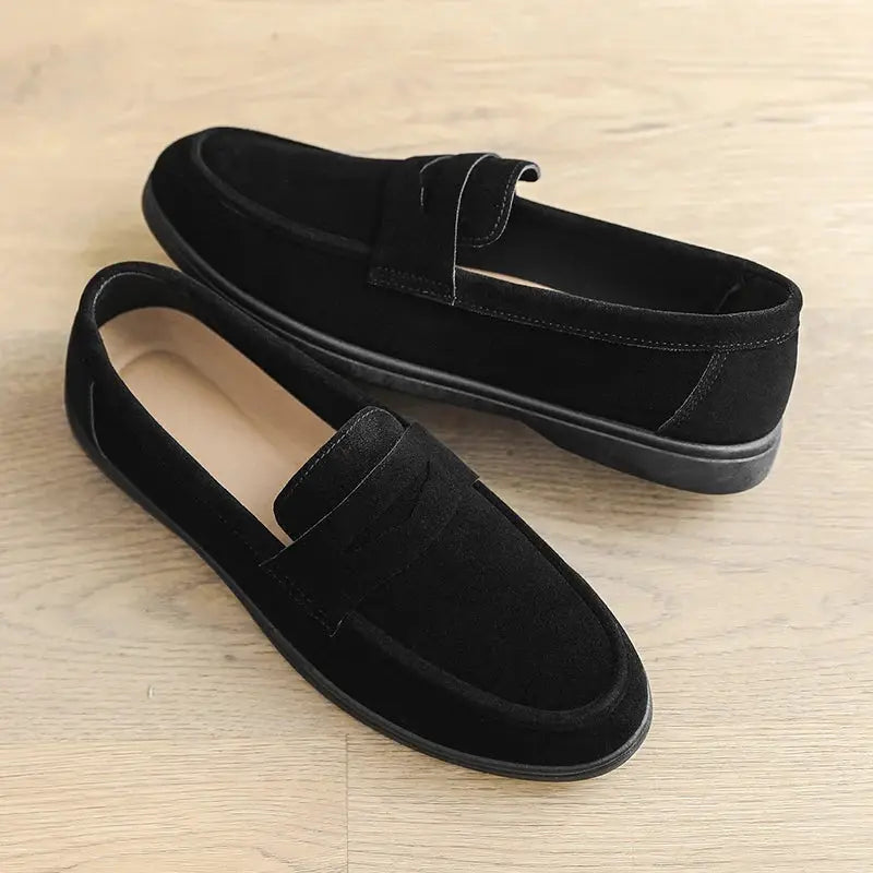 Pair of men's black suede slip-on loafers with penny strap