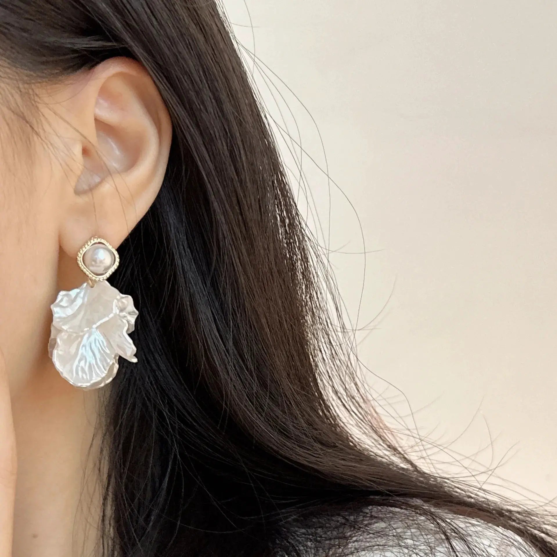 Pearl stud earrings with a gold-tone beaded bezel by Simples Market