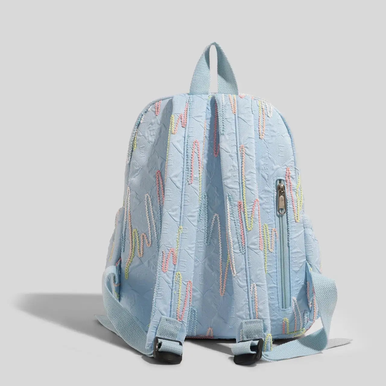 Women's mini backpack by Simples Market in light blue with pastel embroidery, adjustable straps and zipper closure.