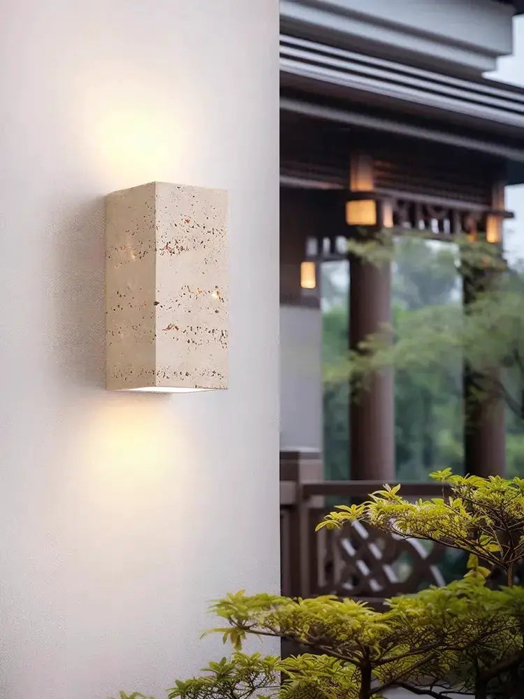 Wabi Sabi yellow travertine marble wall lamp with warm LED glow for bedroom or living room.
