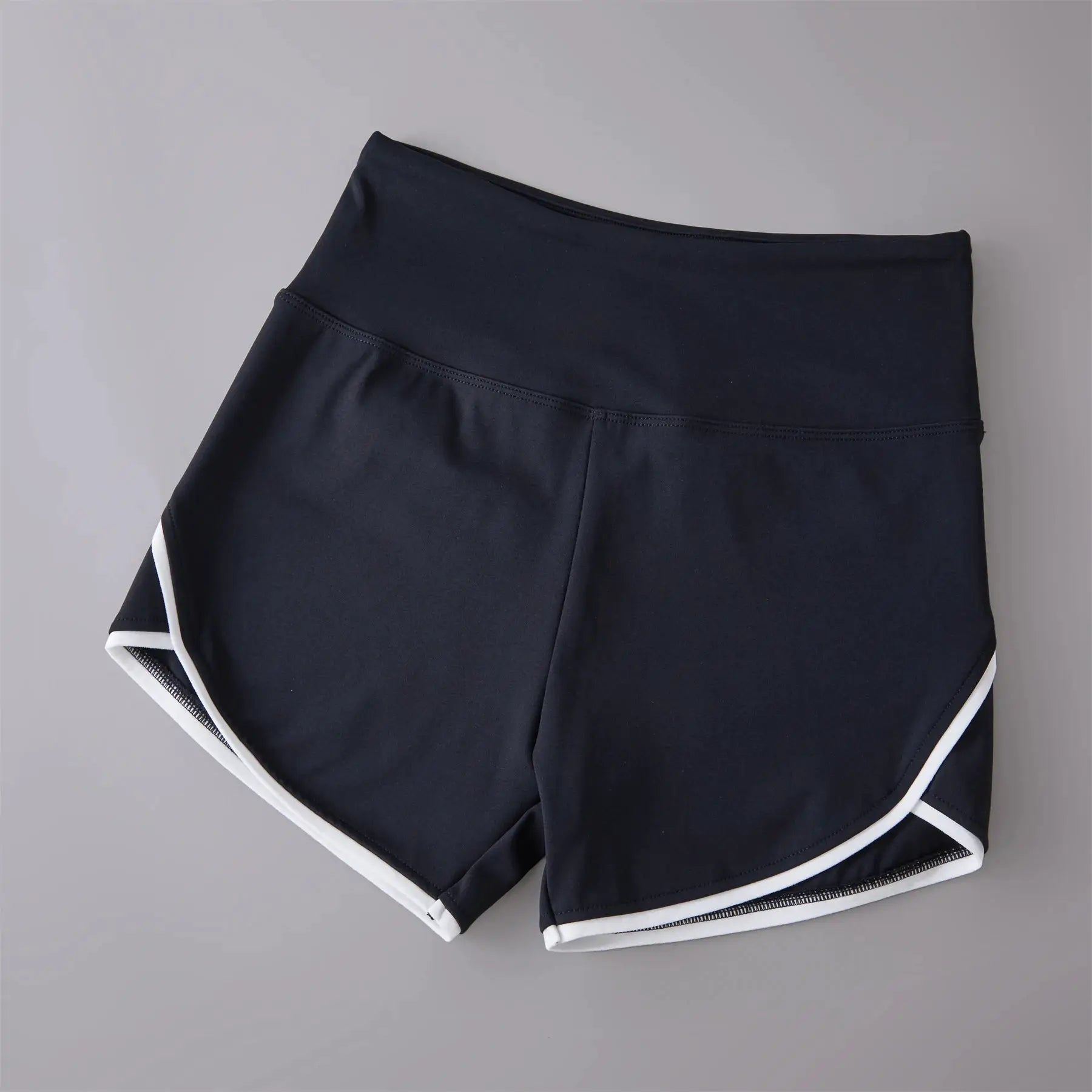 Navy high-waist athletic shorts with white piping along the curved hem