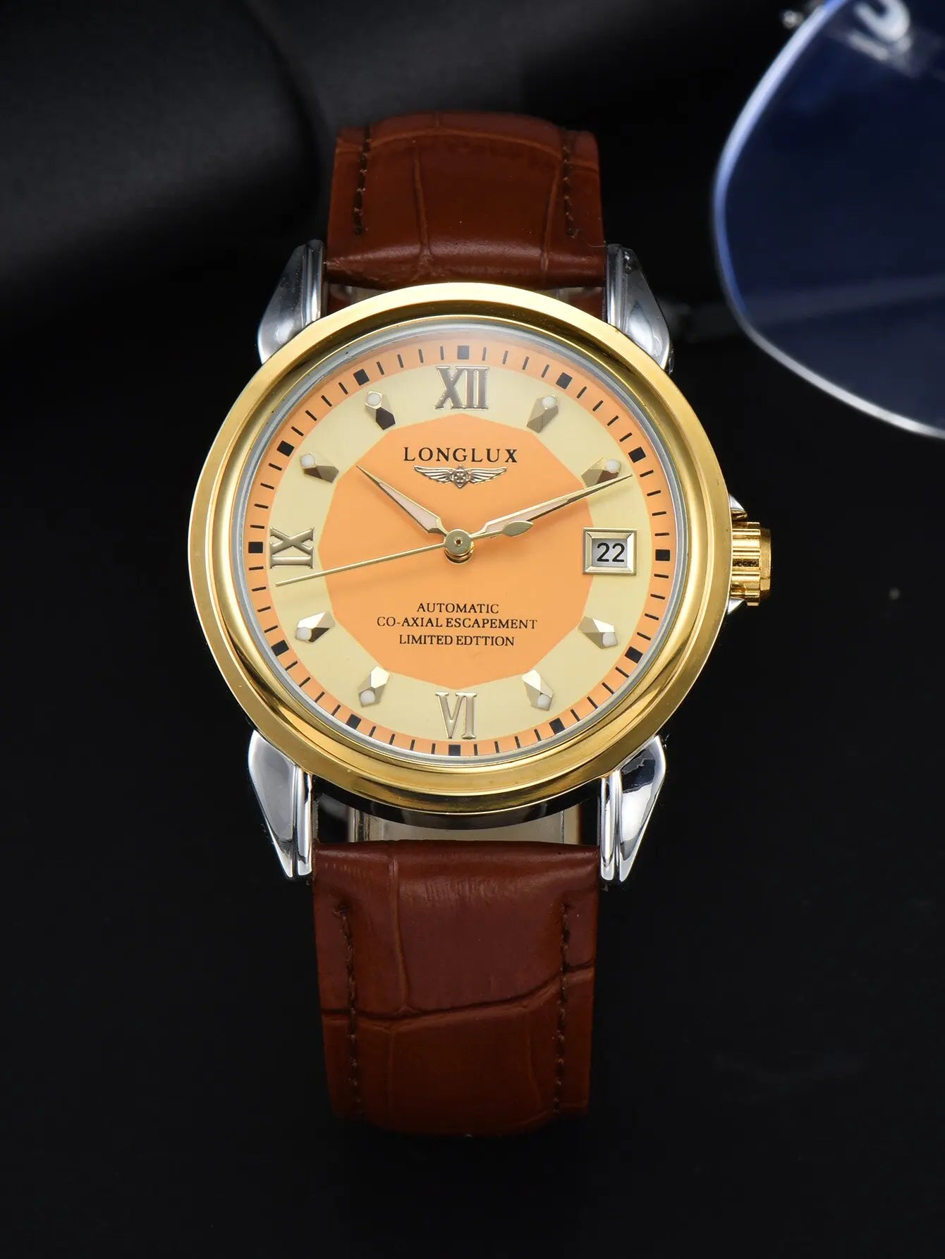 Men's automatic wristwatch with orange dial, gold-tone bezel, brown leather strap; LONG LUX on dial with date window.