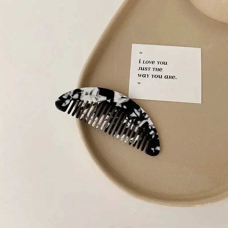 Wide-tooth acetate hair comb by Simples Market, black and white marbled pattern.