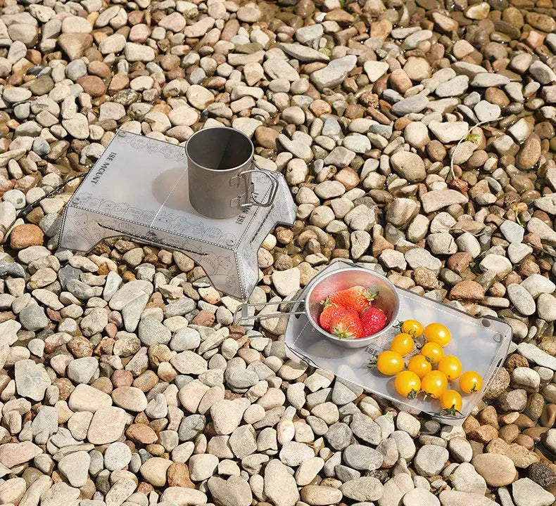 TINSOL ultralight folding camping table and tray; silver metal, two compact pieces with cup on one and fruit on the other