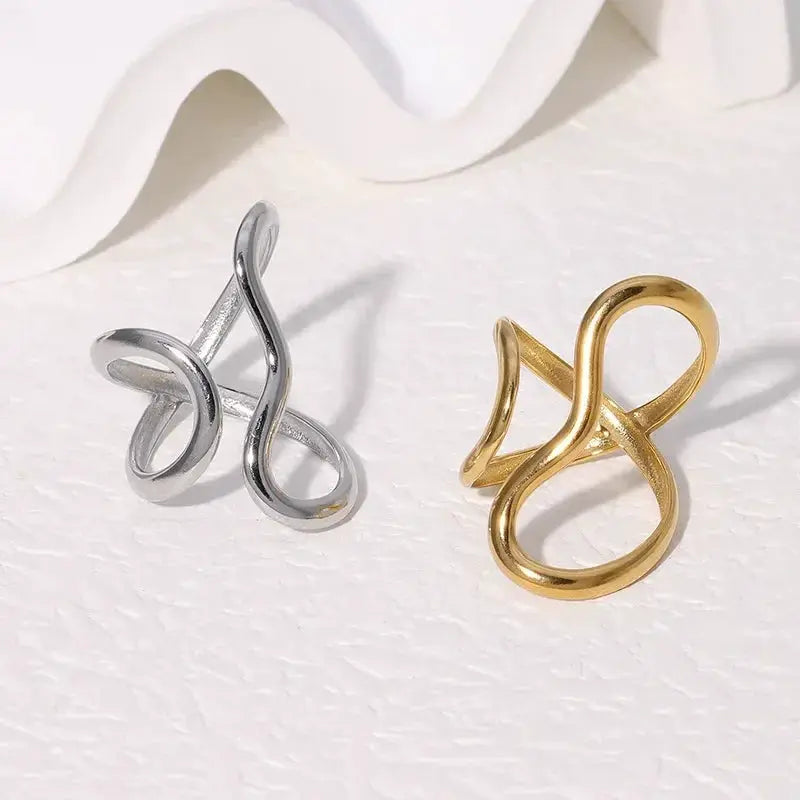 Two irregular stainless steel rings in silver and gold tones with abstract loop designs