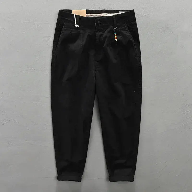 Men's black cargo pants with belt loops, drawstring waist, and rolled cuffs