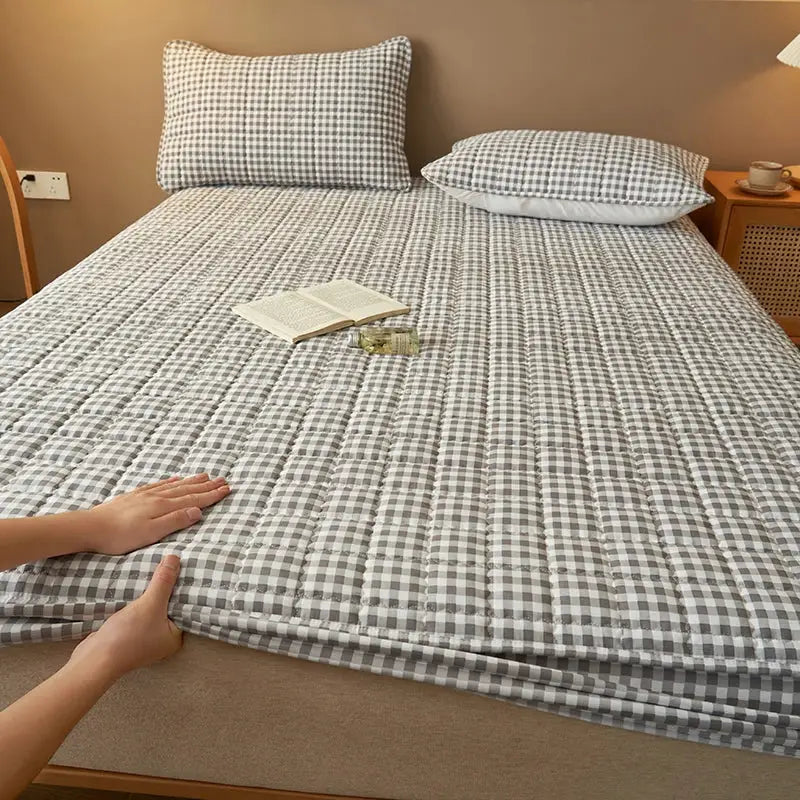 Quilted plaid mattress protector cover in gray and white, antibacterial and breathable.