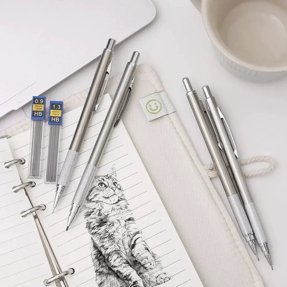 Metal mechanical pencil set with silver stainless steel bodies and 0.3–2.0mm HB lead refills on a notebook