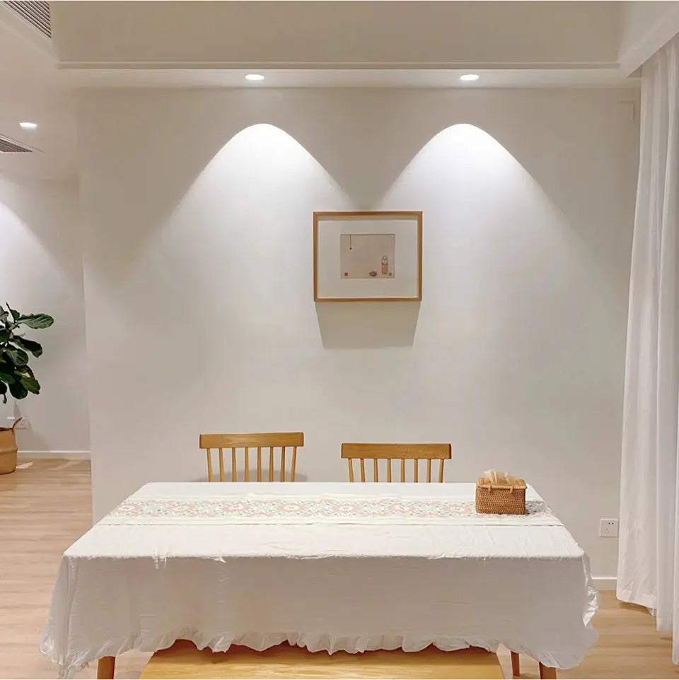 Aluminum LED spot light recessed downlight by Simples Market; two ceiling spotlights illuminate a white dining room