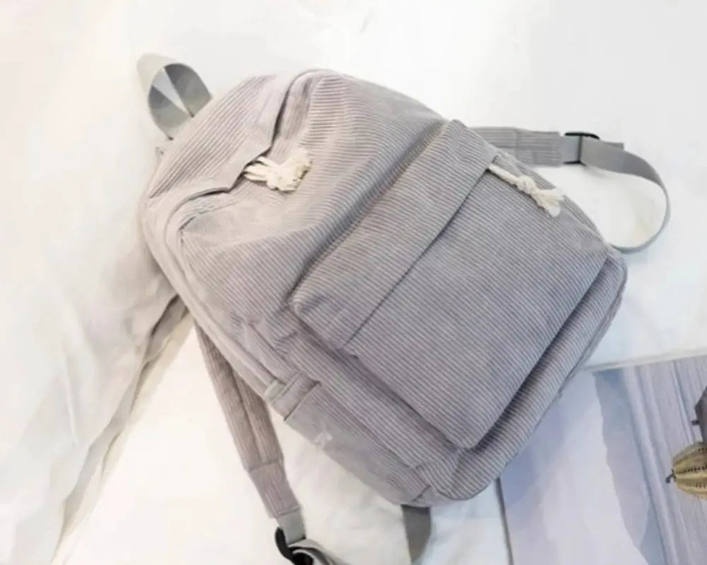 Personalized kids backpack in light gray corduroy with top handle and adjustable straps.