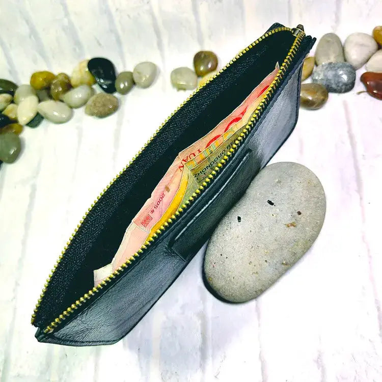 Mini zipper waist bag leather belt pack in black with a yellow zipper, opened to reveal cash.