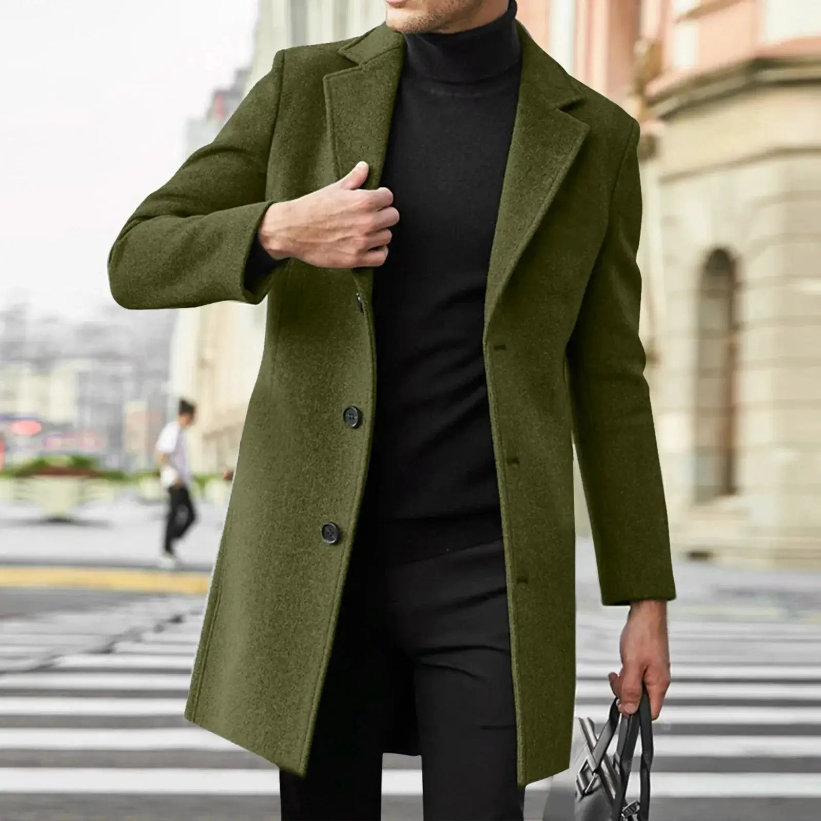 Men's olive-green wool-blend trench coat, long and buttoned, worn over black attire on a city street