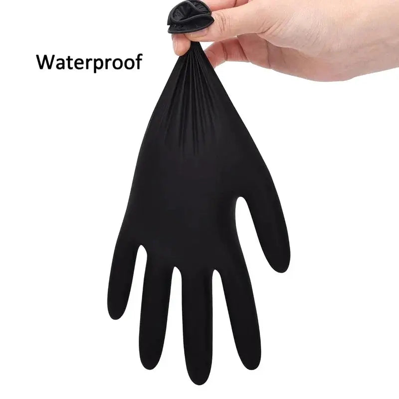 Black nitrile disposable glove; waterproof label visible, held by hand for work, cleaning and beauty uses.