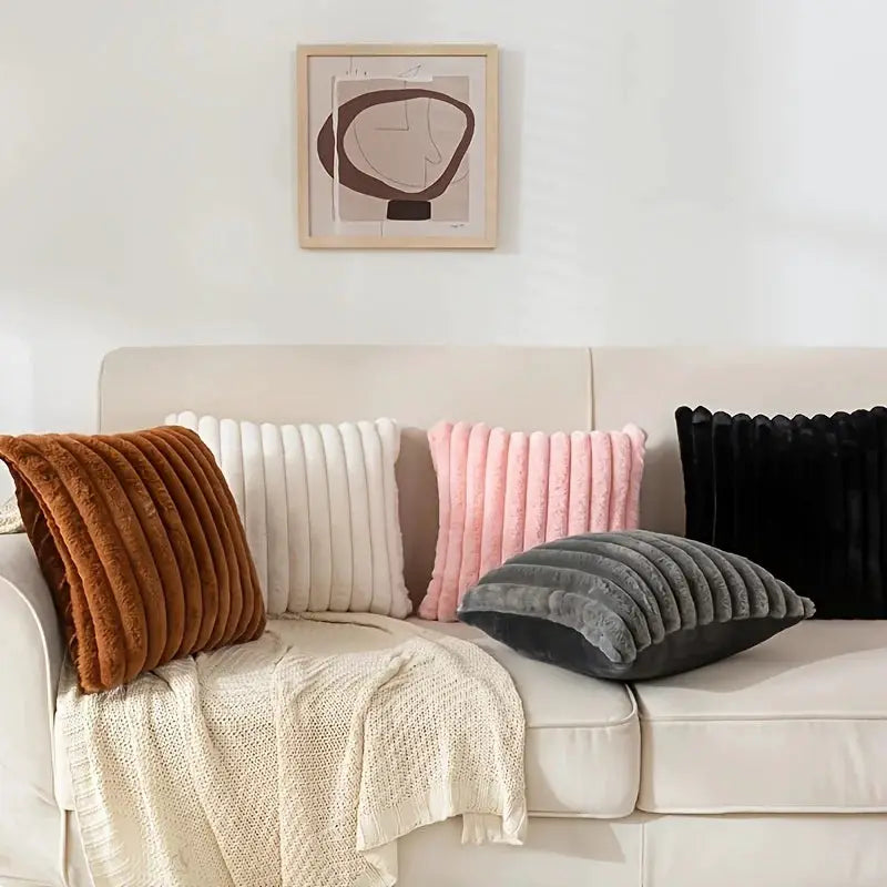 Stripe corduroy pillow covers; brown, white, pink, gray, and black cushions on a cream sofa with a knit throw