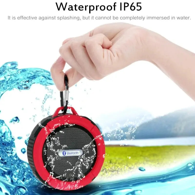 Waterproof Bluetooth speaker, red round portable subwoofer with black grille and metal carabiner clip.
