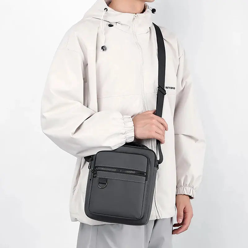 Messenger sling bag in charcoal gray with dual zip pockets and crossbody strap