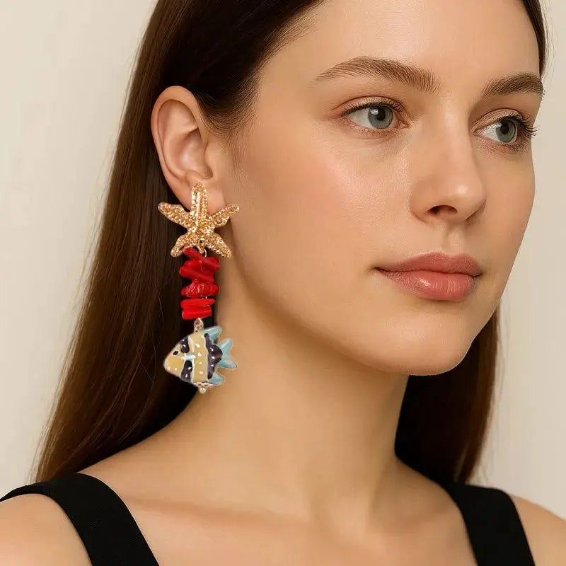 Earrings: long drop with gold starfish top, red beads, and a glass fish pendant