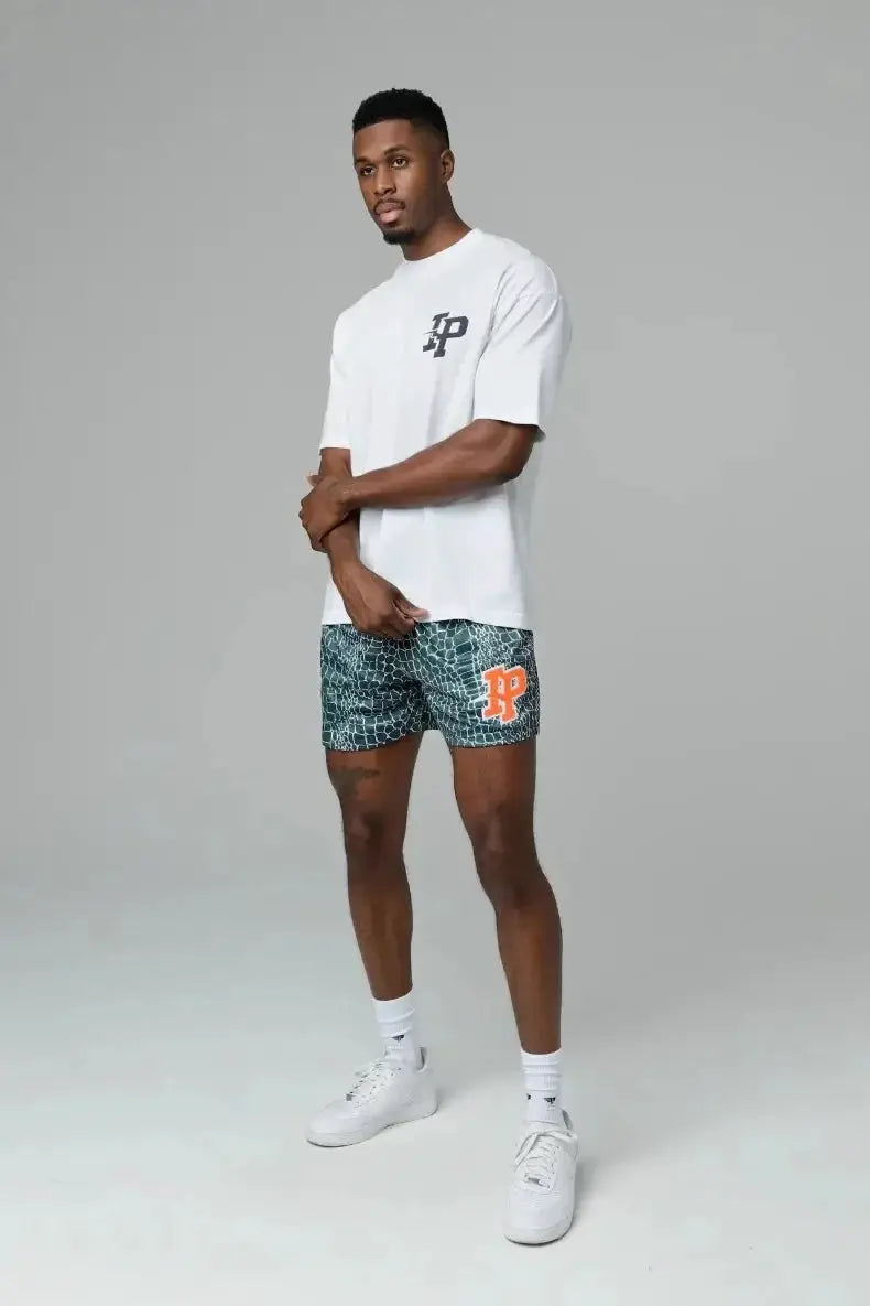 Mens shorts by Simples Market IP Trend; green patterned quick-dry shorts with orange P logo.