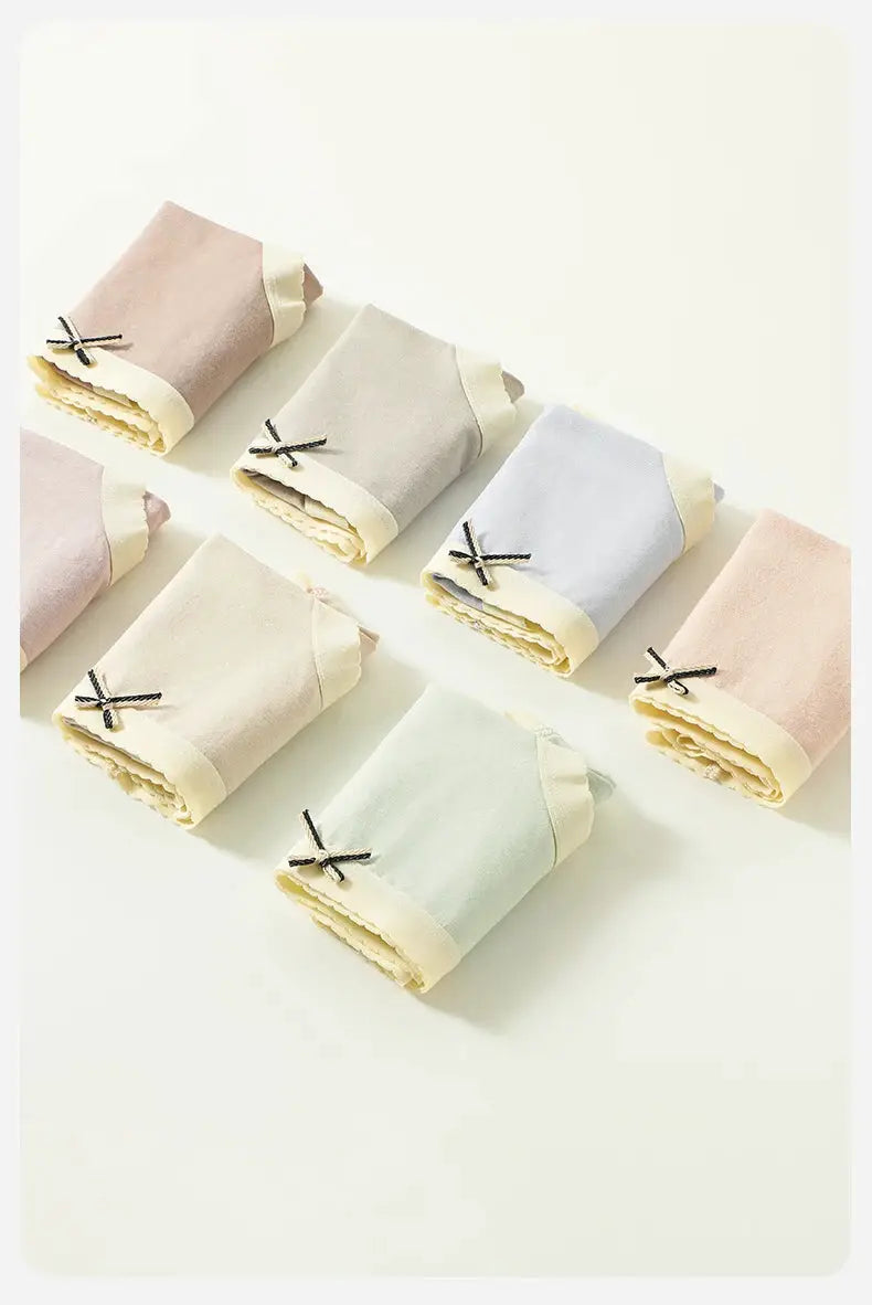 7-pack cotton women’s panties in solid pastel colors with bow accents; breathable low-rise briefs
