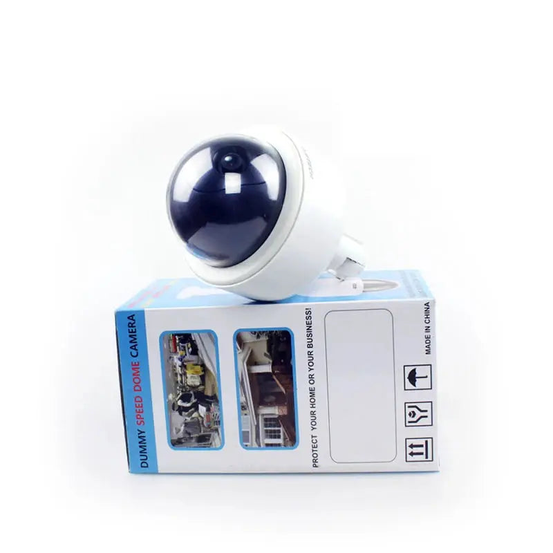Outdoor dummy speed dome camera with white housing and blue-tinted dome on packaging box