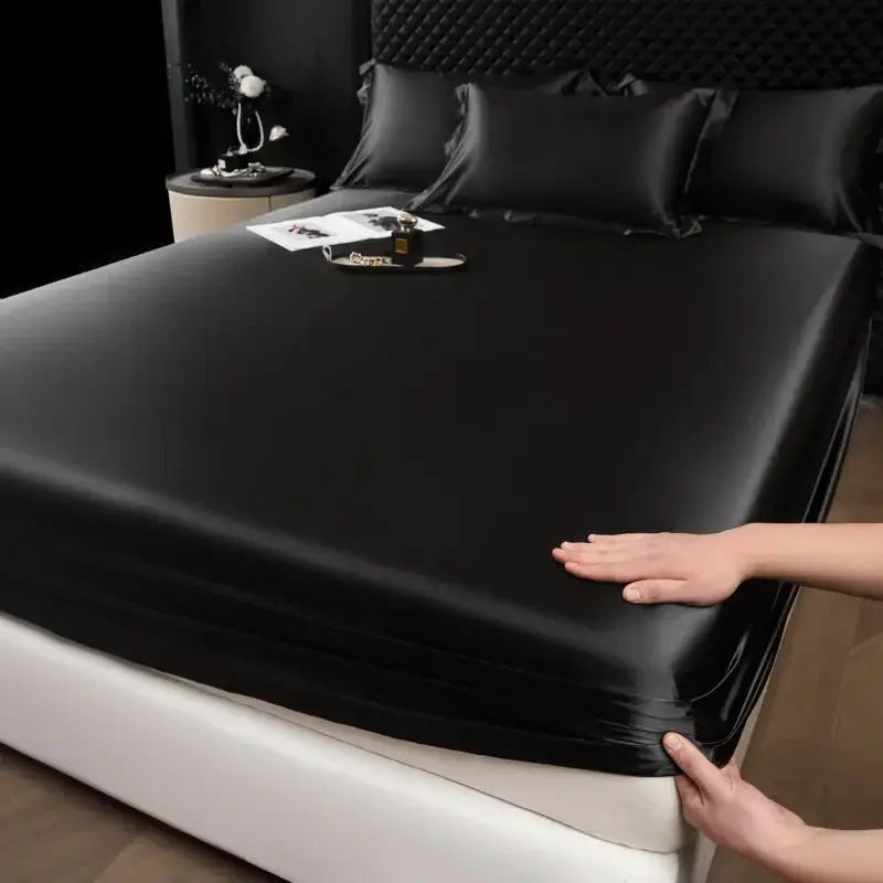 Mulberry silk fitted sheet set in black with pillowcases on a bed